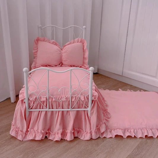 Lit Princesse Surélevé rose pour chiots et petits animaux, cadre métallique blanc avec housse rose et coussins à volants.