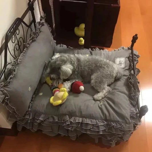 Lit Princesse en fer forgé gris pour animaux, coussins à volants et jouets visibles